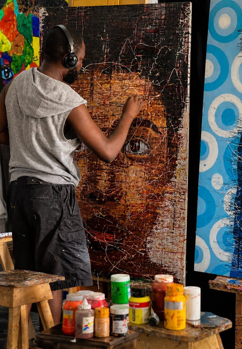 Emmanuel Anaiye Ifebunmi painting in his studio