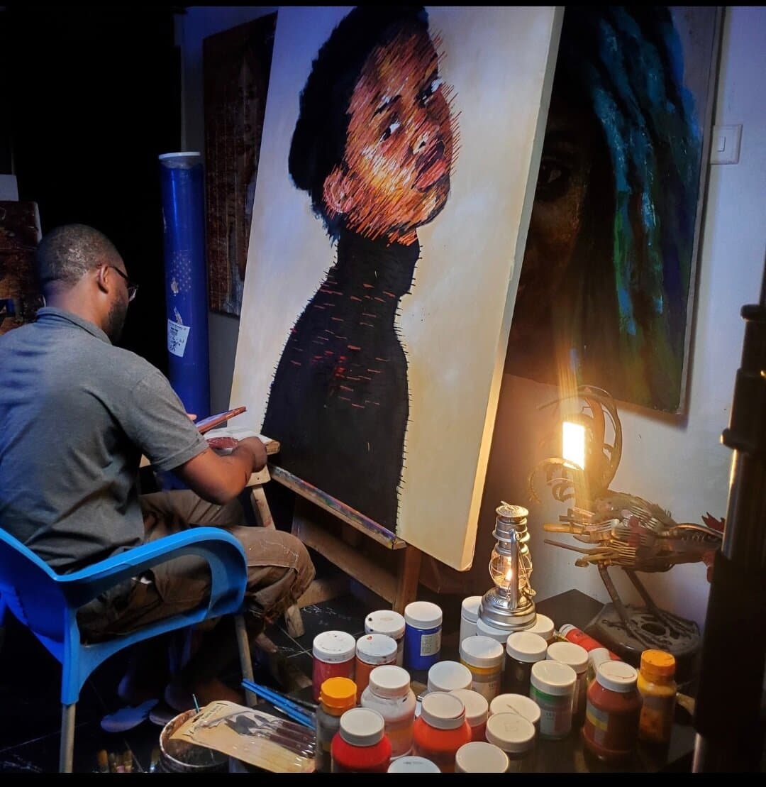 Emmanuel Anaiye Ifebunmi painting in his studio