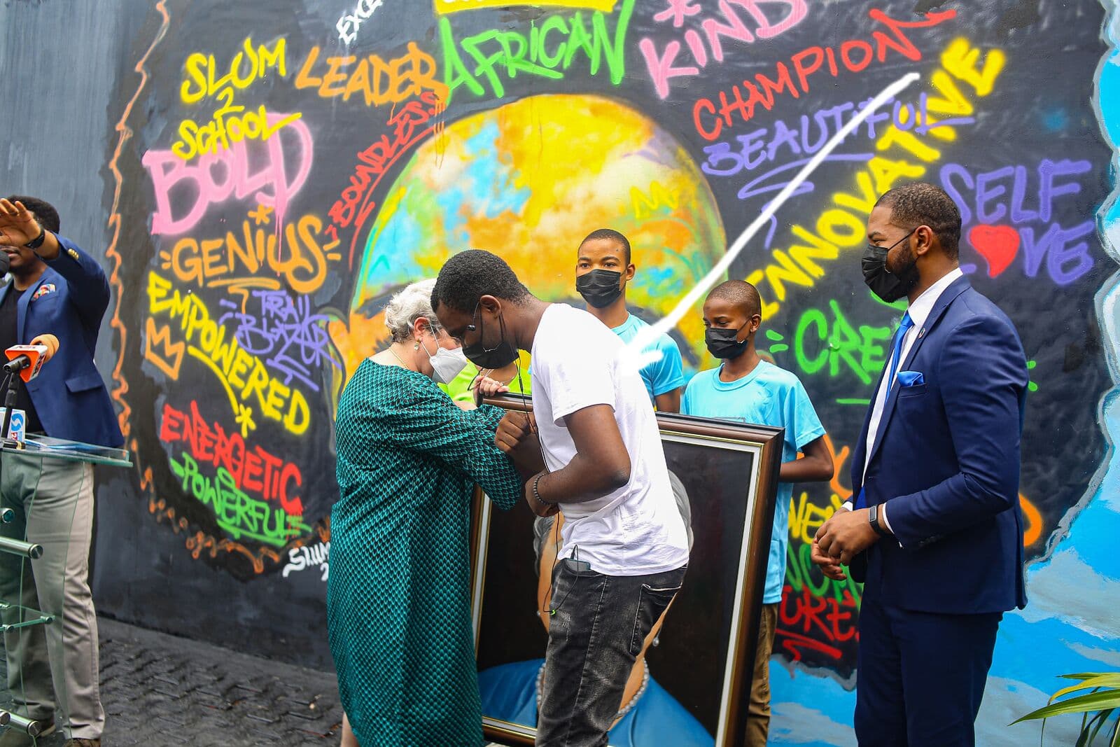Presenting a piece of his work to Ambassador Mary Beth Leonard, with Otto Orondaam, Emmanuel Anaiye Ifebunmi art