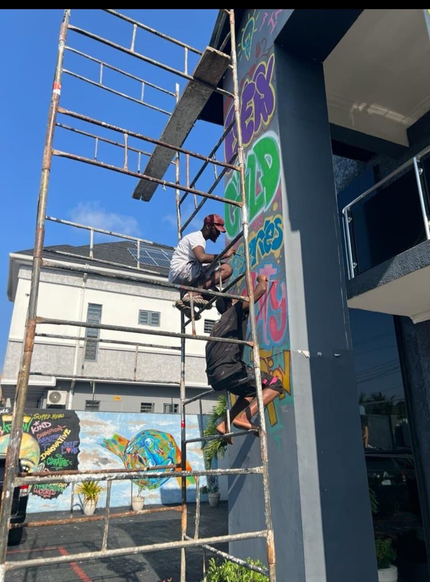 Painting the Innovation Hub mural on site, Emmanuel Anaiye Ifebunmi art