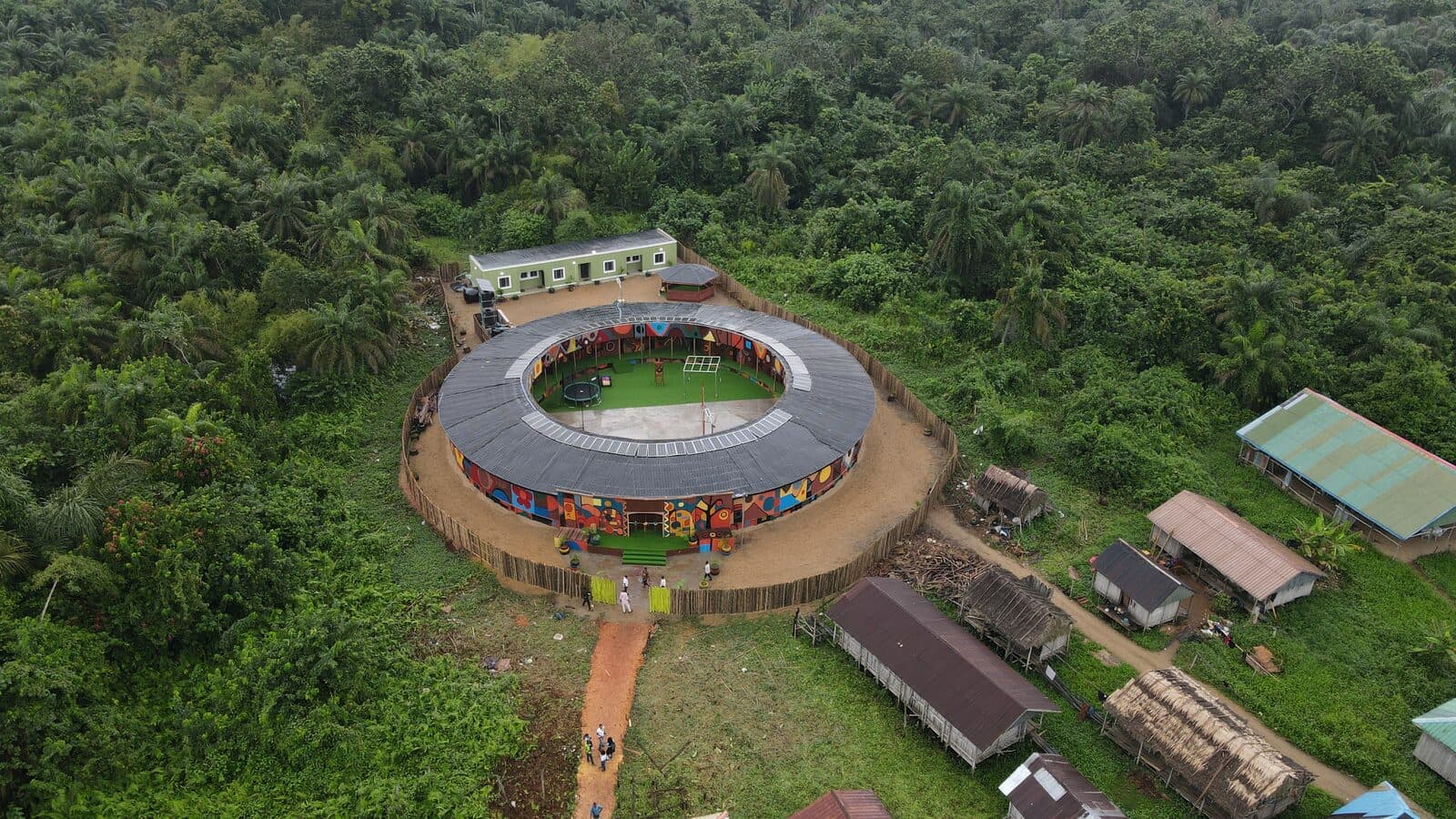 The Saga Project community building, murals wrapped around the exterior, 2026, Emmanuel Anaiye Ifebunmi art